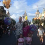 Photo of Dr. Lewis with his wife and daughters at Disneyland